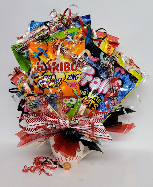Assortment of candies arranged as a bouquet in a Baseball ceramic mug with colorful ribbons and decorations.