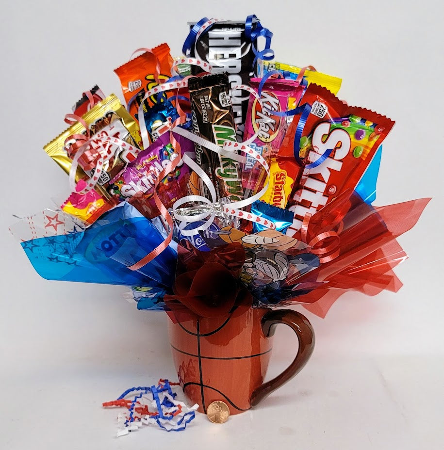 Assortment of candies arranged as a bouquet in a Basketball ceramic mug with colorful ribbons and decorations. 